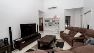 a living room with a couch and a flat screen tv at Tiramula Lodge Holiday House in Horseshoe Bay