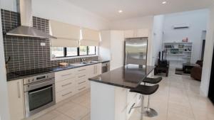 a kitchen with white cabinets and a black counter top at Tiramula Lodge Holiday House in Horseshoe Bay