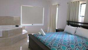 a hotel room with a bed and a bath tub at Tiramula Lodge Holiday House in Horseshoe Bay +7 photos