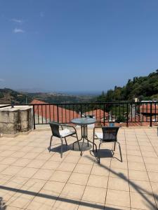 un patio con mesa y sillas en la azotea en Villa Eleva en Aryiroúpolis