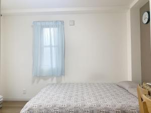 a white bedroom with a bed and a window at ookubo! 大久保! 新宿步行距离! 精品新装公寓! 大久保车站步行7分钟! 干湿分离! 智能马桶! 高速无限制网路 201 in Tokyo