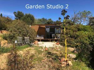 a garden studio in a garden with a house at Montinho Boutique Studio in Benagil