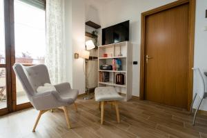 een woonkamer met een stoel en een boekenplank bij Oxilia Flat - Loreto District in Milaan