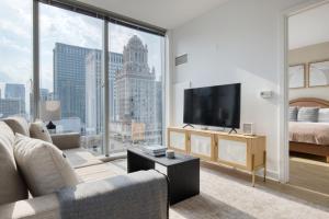 een woonkamer met een televisie en een groot raam bij Loop 2br w gym playroom pool close to L CHI-960 in Chicago