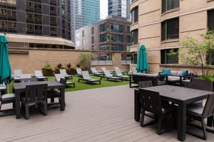 a patio with tables and chairs and buildings at Streeterville Studio w Dog Run Deck nr Park CHI-584 in Chicago