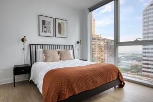 een slaapkamer met een bed en een groot raam bij Loop 2br w gym playroom pool close to L CHI-960 in Chicago +47 foto's
