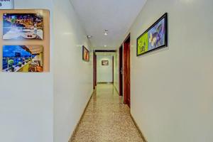 a hallway with paintings on the walls and a hallway with a hallwayngth at Capital O Sri Krishna Suites Near 7d Voyage in Bangalore
