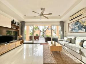 ein Wohnzimmer mit Sofa und Fernseher in der Unterkunft Sunrise Beach Villa in Ko Chang