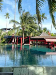 una piscina de agua con palmeras y un edificio en Sunrise Beach Villa, en Ko Chang