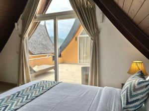 ein Schlafzimmer mit einem Bett und einem großen Fenster in der Unterkunft Sunrise Beach Villa in Ko Chang + 21 Fotos