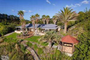 an aerial view of a house with palm trees at Seascape Point - Mahinepua Bay Clifftop Retreat in Mahinepua