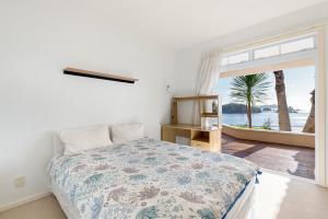 a bedroom with a bed with a view of the ocean at Seascape Point - Mahinepua Bay Clifftop Retreat in Mahinepua