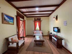 a living room with a couch and a tv at La Digue Holiday Villa in La Digue