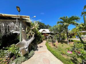 a garden with a statue next to a house at La Digue Holiday Villa in La Digue