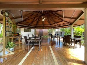 eine offene Terrasse mit Tischen und Stühlen auf einem Holzboden in der Unterkunft La Digue Holiday Villa in La Digue