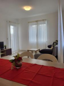 a living room with a red cloth on a table at Apartments A&A in Biograd na Moru