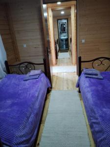 two beds in a room with a hallway at HOTEL AMIRAN in Tusheti