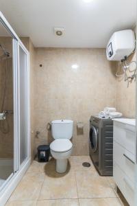 ein Badezimmer mit einem WC, einer Dusche und einer Waschmaschine in der Unterkunft Home2Book Charming Studio Playa del Inglés in San Bartolomé de Tirajana