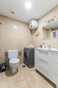 ein Badezimmer mit einem WC und einer Waschmaschine. in der Unterkunft Home2Book Charming Studio Playa del Inglés in San Bartolomé de Tirajana