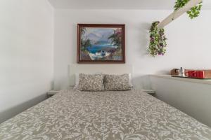 ein Bett in einem Schlafzimmer mit einem Bild an der Wand in der Unterkunft Home2Book Charming Studio Playa del Inglés in San Bartolomé de Tirajana