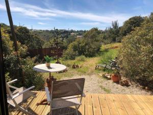 a patio with a table and chairs on a wooden deck at Montinho Boutique Studio in Benagil