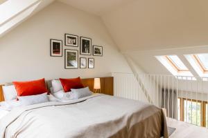 a bedroom with a large white bed with red pillows at Landgut am Pößnitzberg in Leutschach