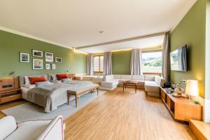 a bedroom with a large bed and a living room at Landgut am Pößnitzberg in Leutschach