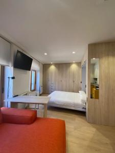 Schlafzimmer mit einem Bett, einem Tisch und einem TV in der Unterkunft Apartamentos ARVA París in León