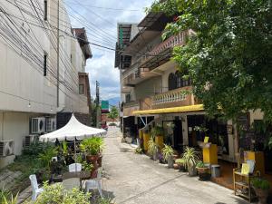 uma rua com um edifício com uma tenda e plantas em Kamala's Boutique Guesthouse em Chiang Mai