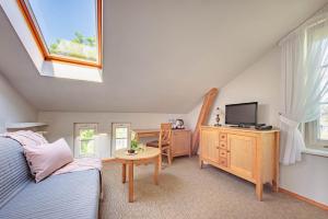 a bedroom with a bed and a desk with a television at Villa Sedan in Sopot