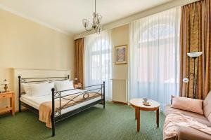 Habitación de hotel con cama y sofá en Villa Sedan en Sopot