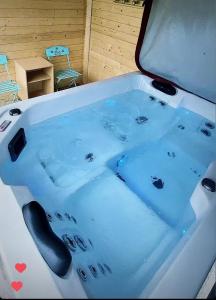 een bad gevuld met blauw water in een kamer bij La chambre secrète in Longueval