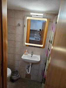 uma casa de banho com um lavatório e um espelho em Nick's Place em Tessalônica