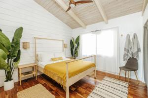 1 dormitorio con cama, escritorio y planta en The Koi House with Pool, en Kailua-Kona