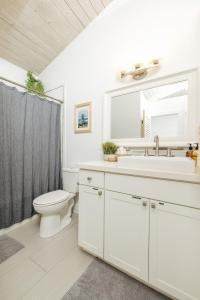 La salle de bains blanche est pourvue d'un lavabo et de toilettes. dans l'établissement The Koi House with Pool, à Kailua-Kona