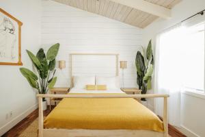 1 dormitorio con 1 cama con colcha amarilla en The Koi House with Pool, en Kailua-Kona