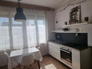 uma cozinha com uma mesa branca, uma mesa e cadeiras em Cosy 2 room apartment with nice vibe, for up to 4 em Ljubljana