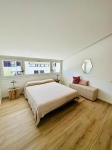 una camera con un grande letto e un divano di Marina Dream House a Lignano Sabbiadoro