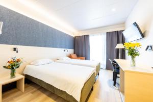 een hotelkamer met 2 bedden en een bureau bij Saaremaa Rannahotell ' Beach Hotel in Mändjala