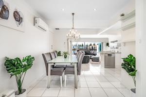 a dining room and living room with a table and chairs at Swainson on Gulf Point in Largs