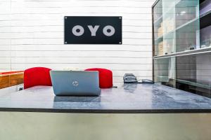 a table with a laptop and two red chairs at Hotel O Aroma Classic Near Nampally Main Railway station in Hyderabad