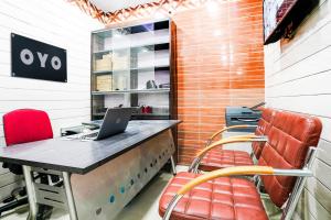 an office with a desk with a laptop and chairs at Hotel Aroma Classic Near Nampally Main Railway station in Hyderabad
