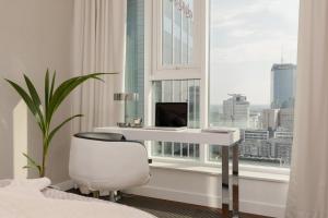 a bedroom with a desk and a chair in front of a window at Premium LUX Apartments Unique Tower Heart of Warsaw by Renters Prestige in Warsaw