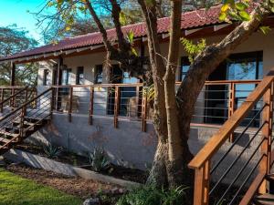 a house with a tree in front of it at Khululeka Safaris Lodge in White River