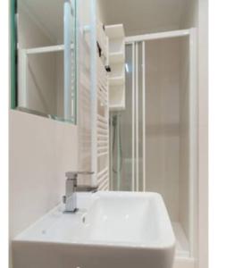 een badkamer met een witte wastafel en een spiegel bij Apartment Vltavska A in Praag
