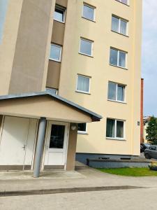 a building with a white door in front of it at One bedroom studio apartment in Ikskile in Ikšķile