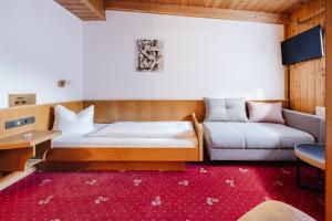 a bedroom with a bed and a couch at Hotel Andrea in Zams