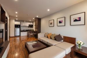 a living room with a couch and a kitchen at The Grand Napat in Chiang Mai