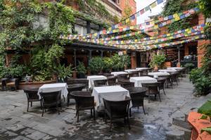 um restaurante ao ar livre com mesas, cadeiras e plantas em Dalai-La Boutique Hotel em Kathmandu