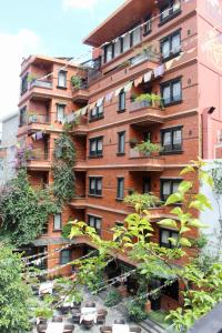 um edifício alto de tijolos vermelhos com plantas sobre ele em Dalai-La Boutique Hotel em Kathmandu